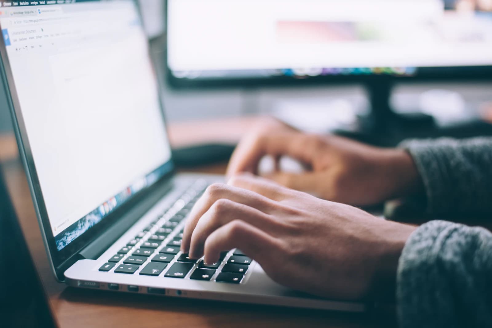Person working on laptop completing online tax preparation at a home office desk